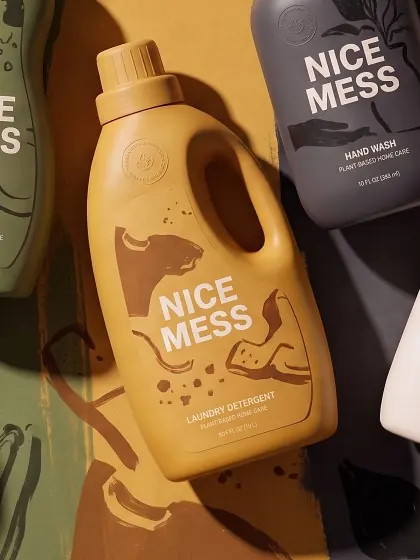 Laundry Detergent bottle lying on a mustard painted backdrop